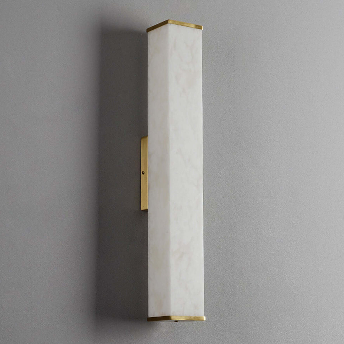 Wall-mounted light fixture with marble-like finish and gold accents on a gray background