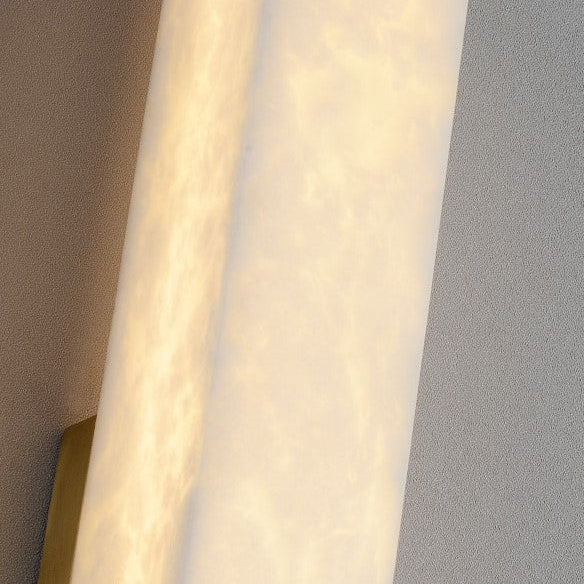 Wall-mounted light fixture with gold trim on a gray wall