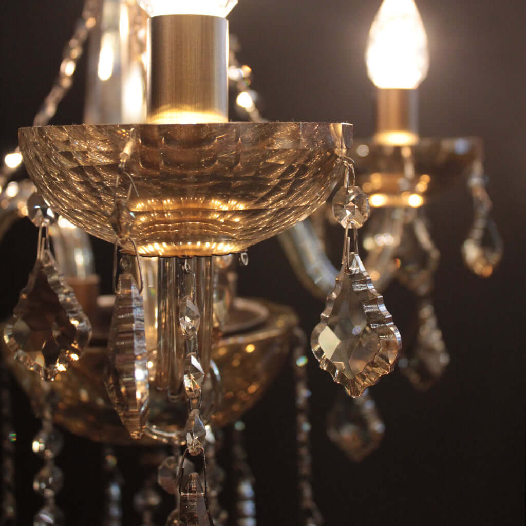 Close-up of a chandelier with amber toned crystal details on a dark background