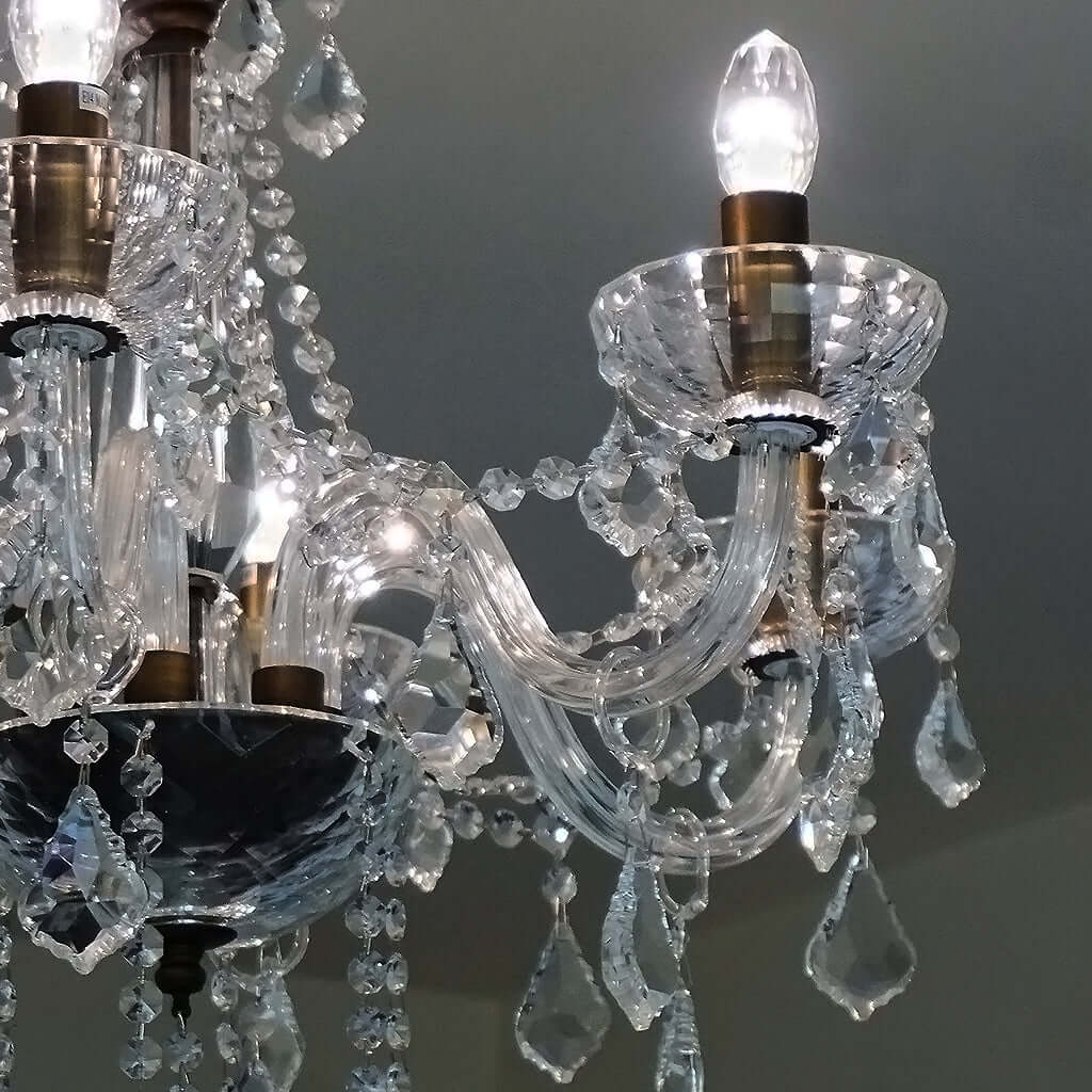Close-up of a crystal chandelier with clear crystal and brass fixtures.