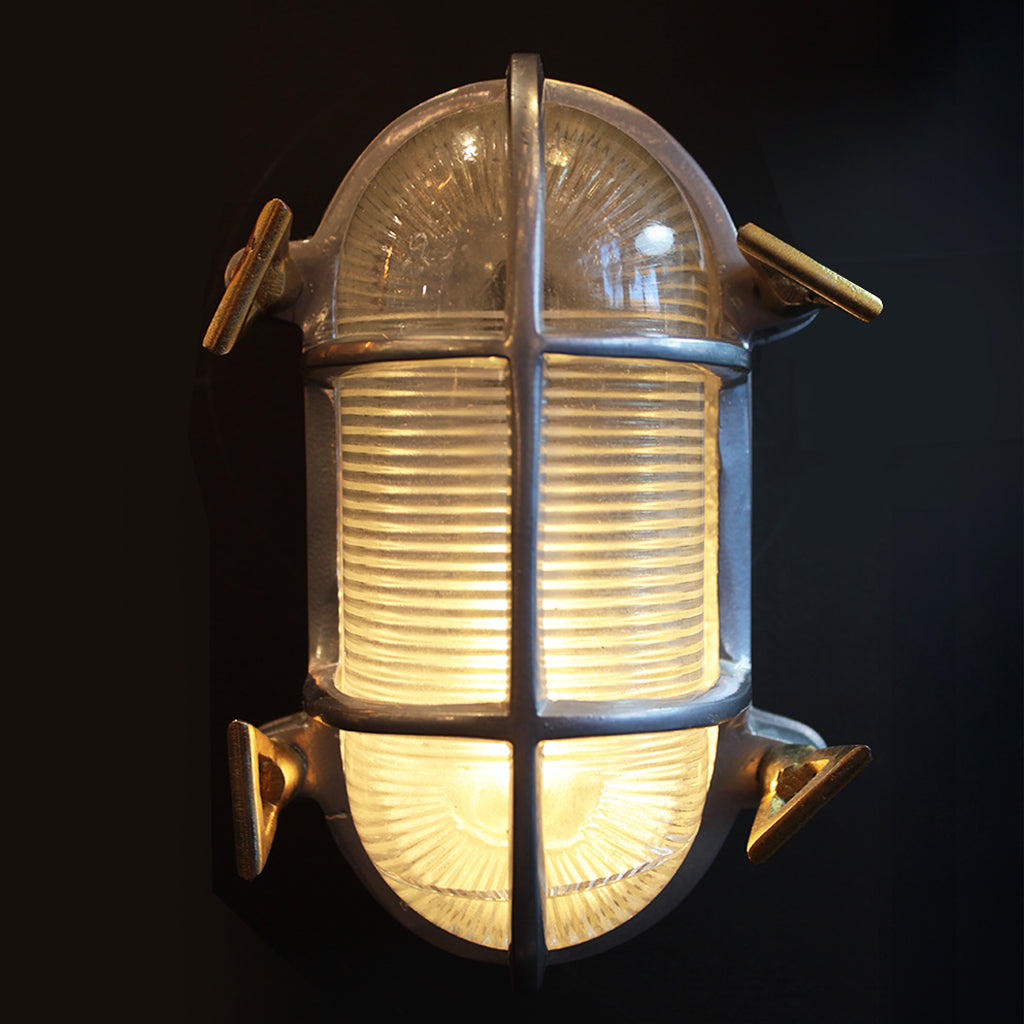 Vintage-style wall light fixture with glass cover on a black background
