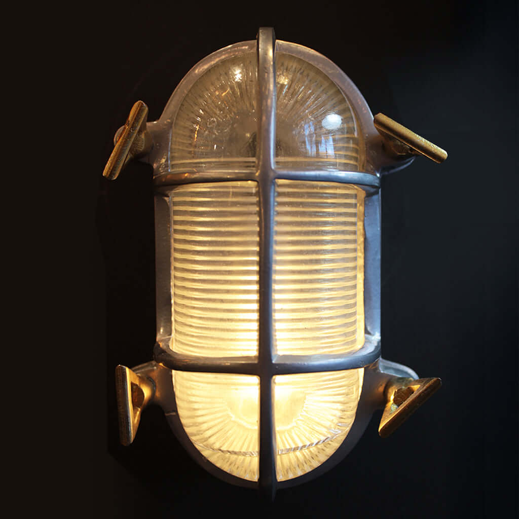 Vintage-style wall light fixture with glass cover on a black background