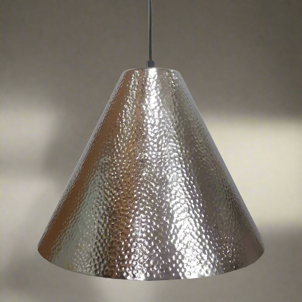 Metallic pendant light with a textured surface on a neutral background
