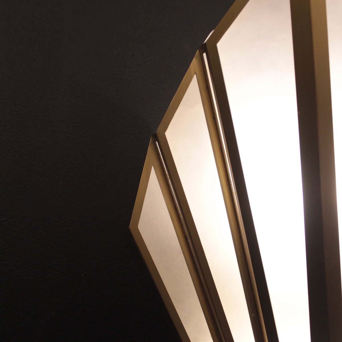 Modern wall sconce with geometric design on a black background