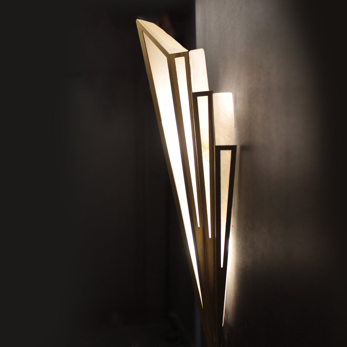 Modern wall sconce with geometric design on a dark background