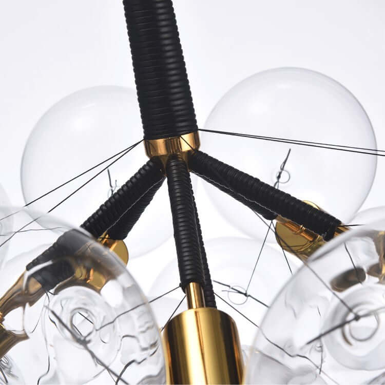 Close-up of a modern chandelier with glass shades and gold accents.