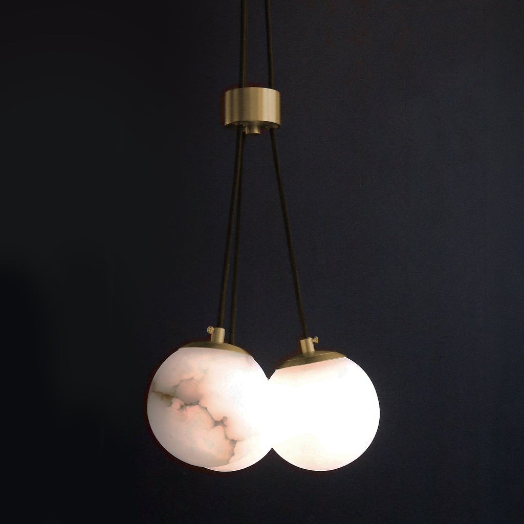Modern pendant light with marble-like globes on a dark background