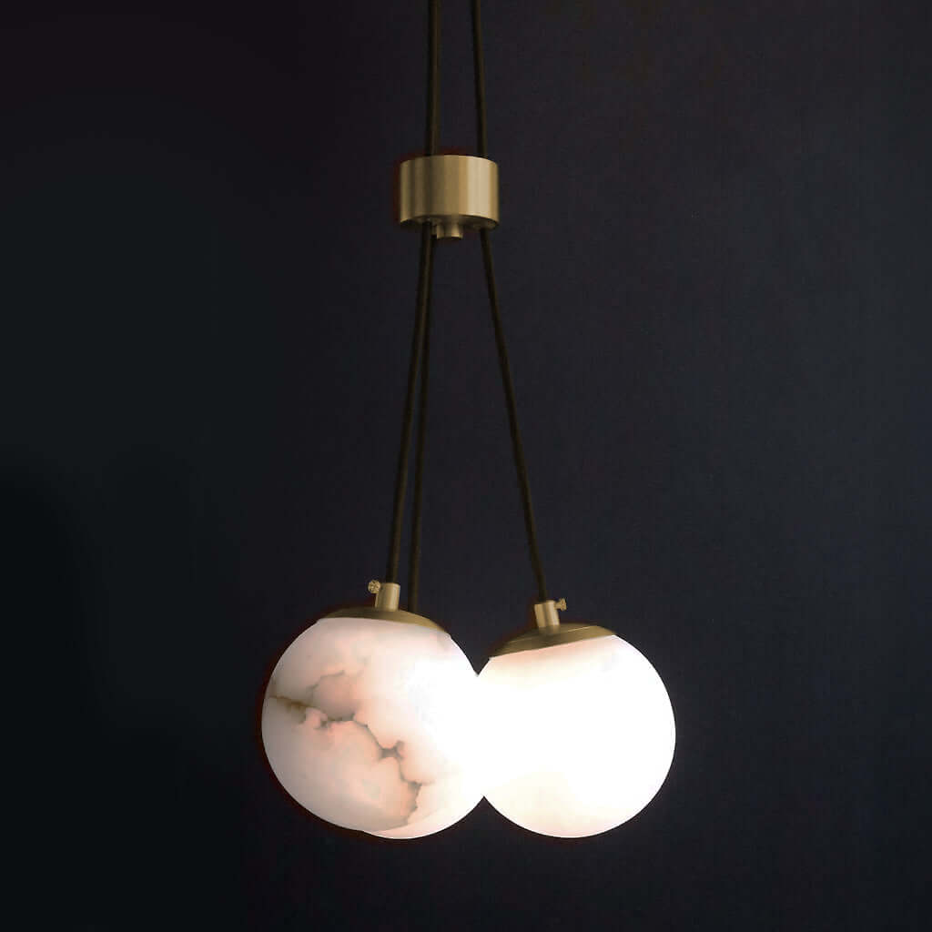 Modern pendant light with marble-like globes on a dark background