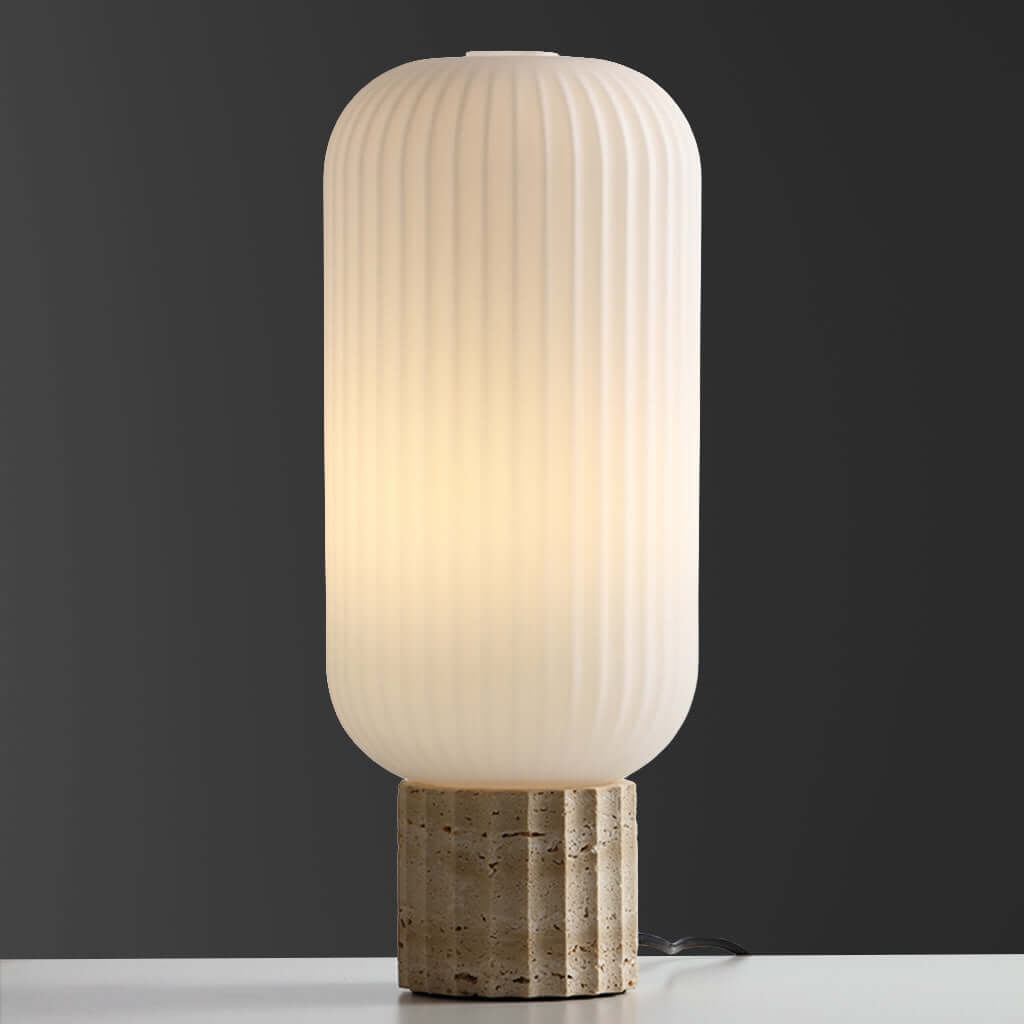 Table lamp with ribbed glass shade and stone base on a dark background