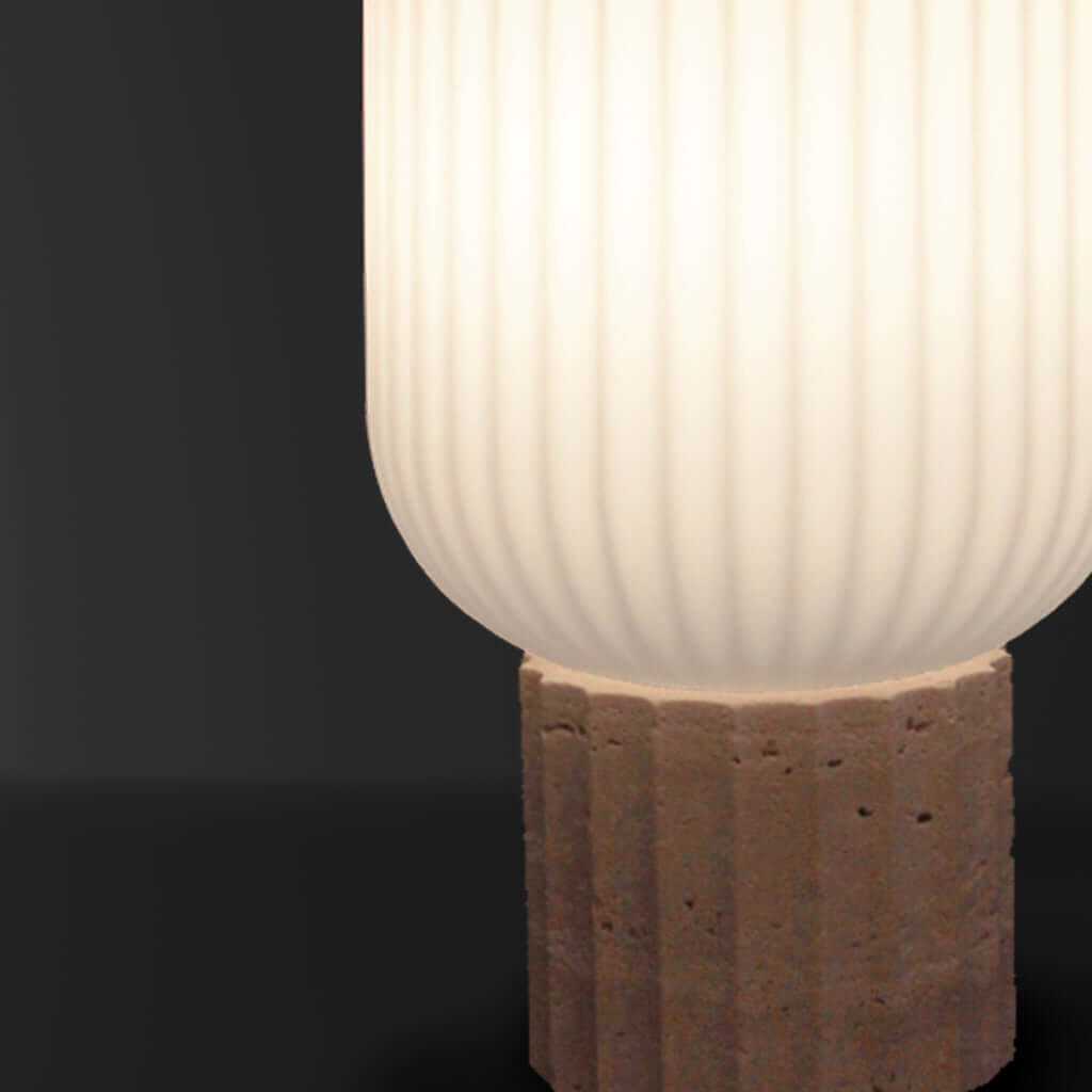 Table lamp with ribbed glass shade and stone base on a dark background