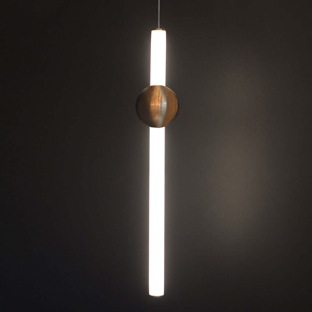 Modern pendant light with a cylindrical shade and spherical copper fixture on a dark background