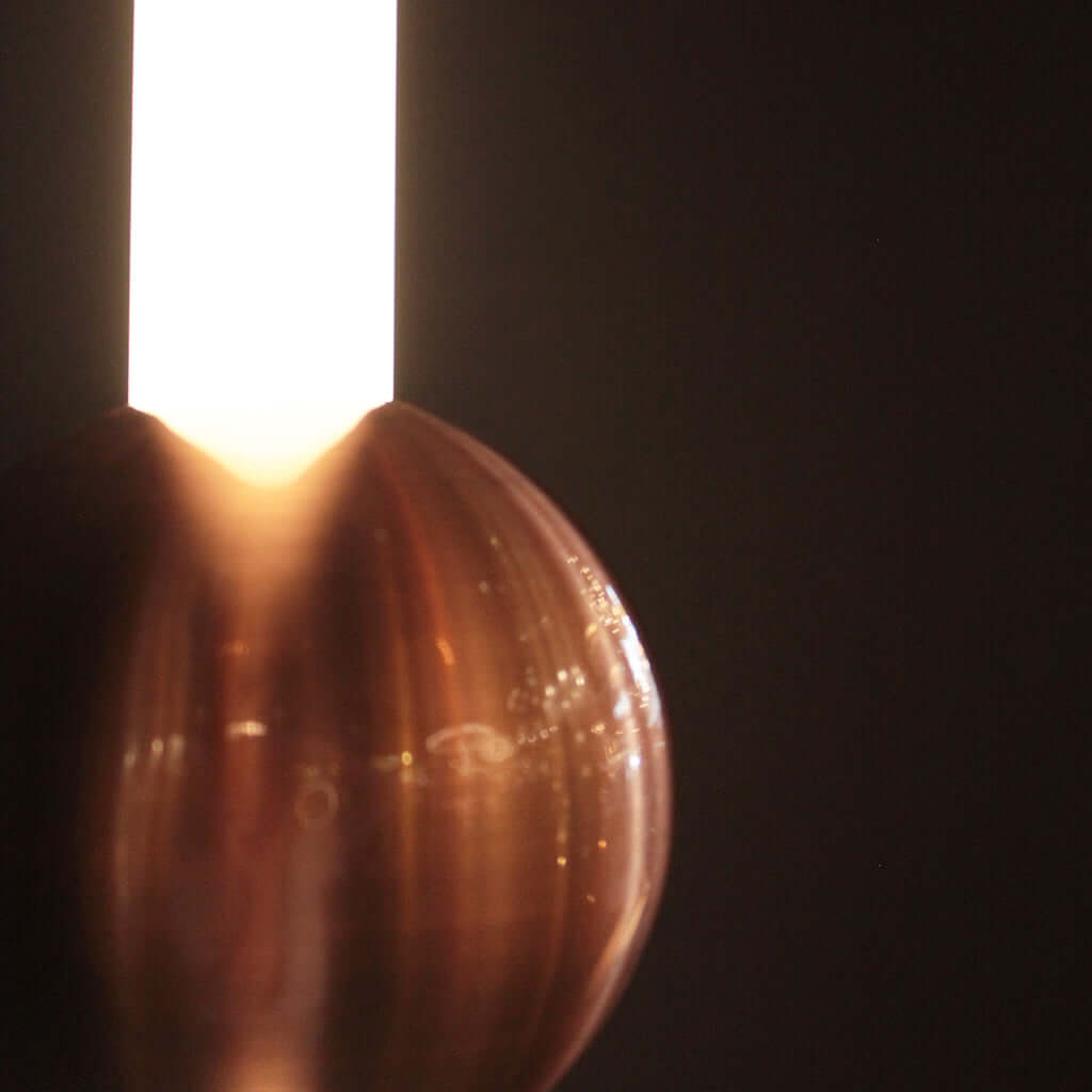Close-up of a copper spherical object with a dark background