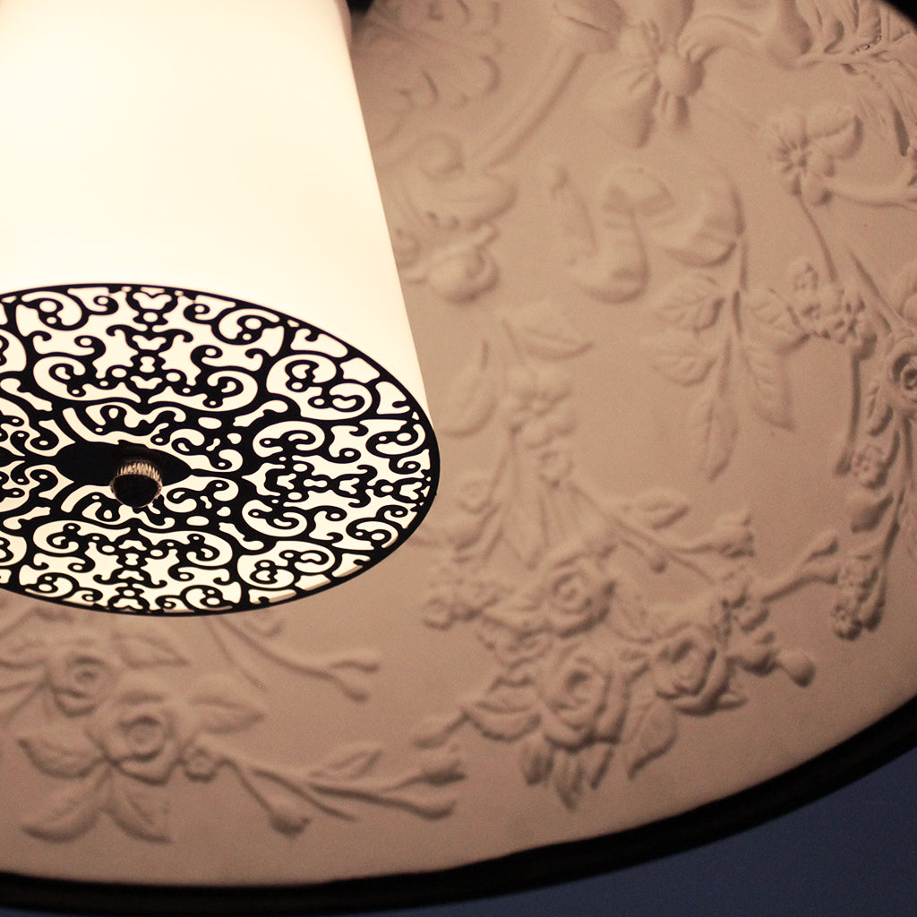 Black pendant light with textured interior on a dark background