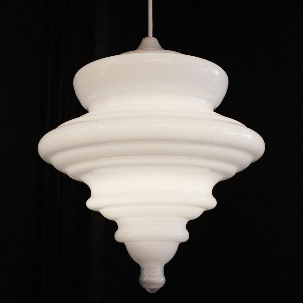 A vintage-style white glass pendant chandelier with a tiered, flared design, suspended against a solid black background.