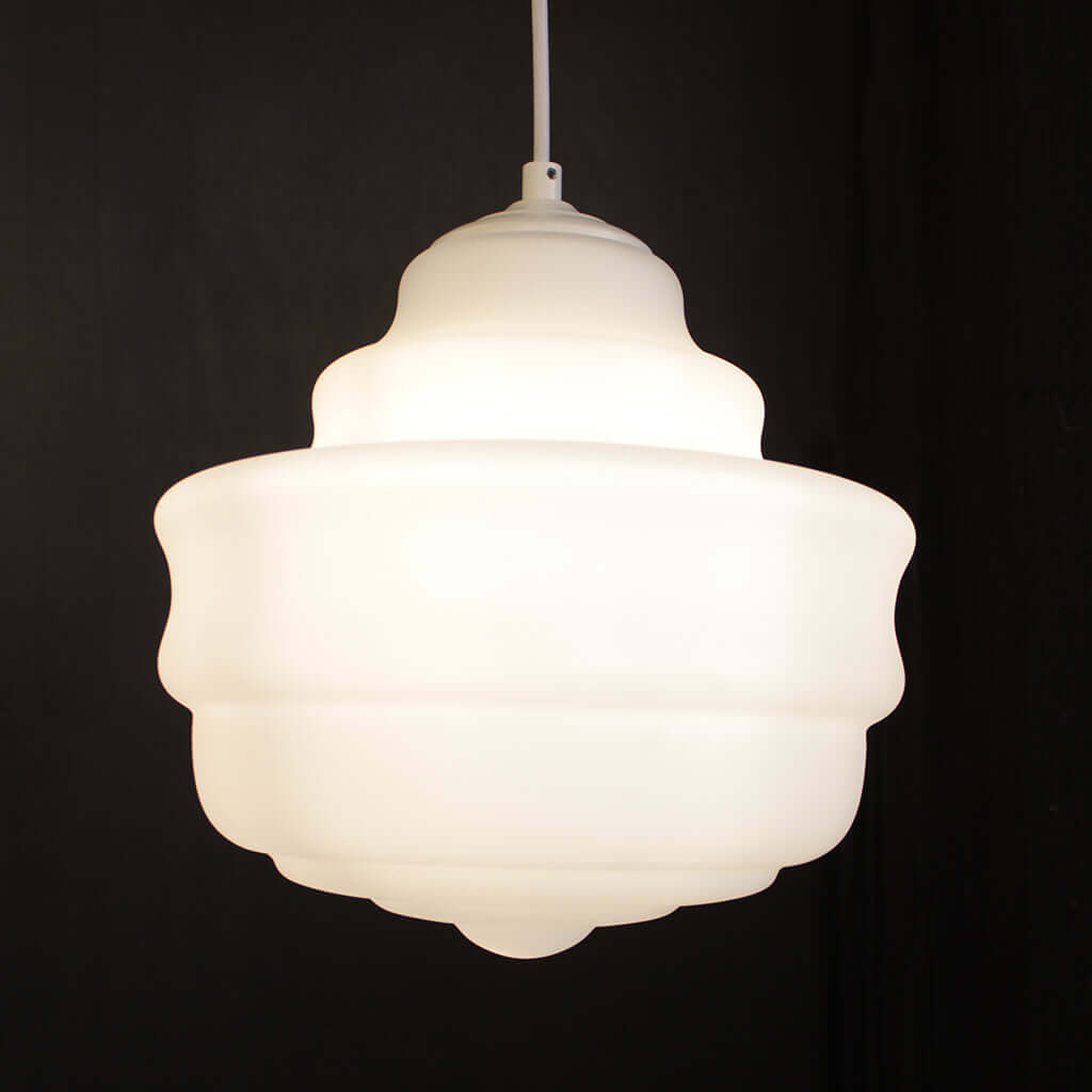 Two white glass pendant lights with a opaque white finish, hanging against a dark background.