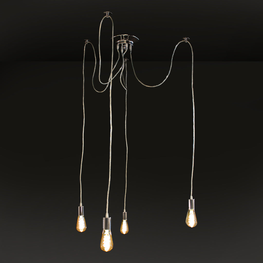 A modern multi-light pendant chandelier with our hanging Edison-style bulbs suspended from a polished metal ceiling canopy by long cords, shown against a dark studio background.