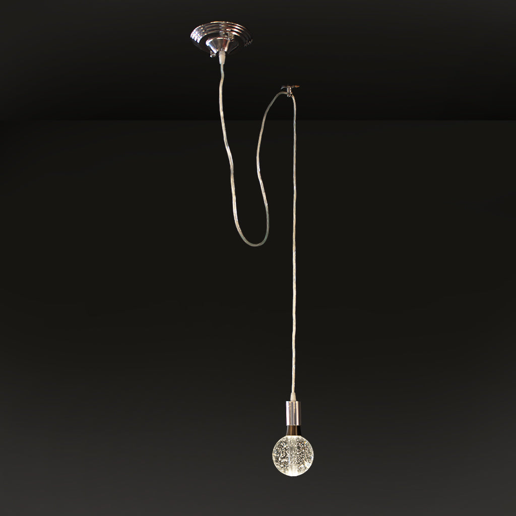 Silver pendant light with crystal bulb against dark background