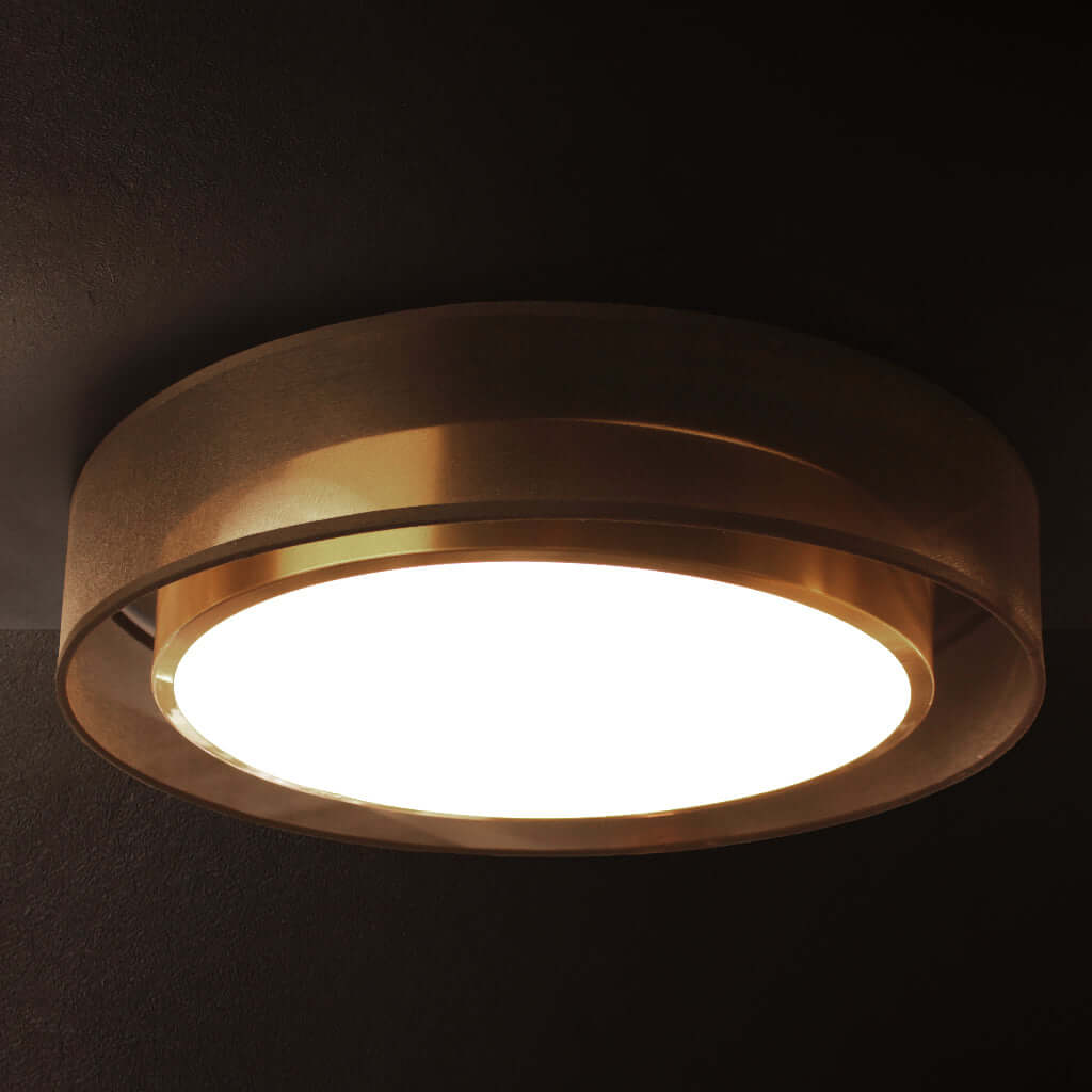 Ceiling light fixture with a gold finish on a dark background