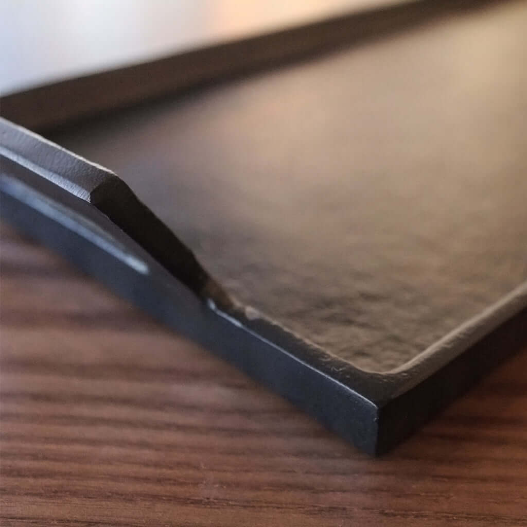 Dark metal tray on a wooden surface