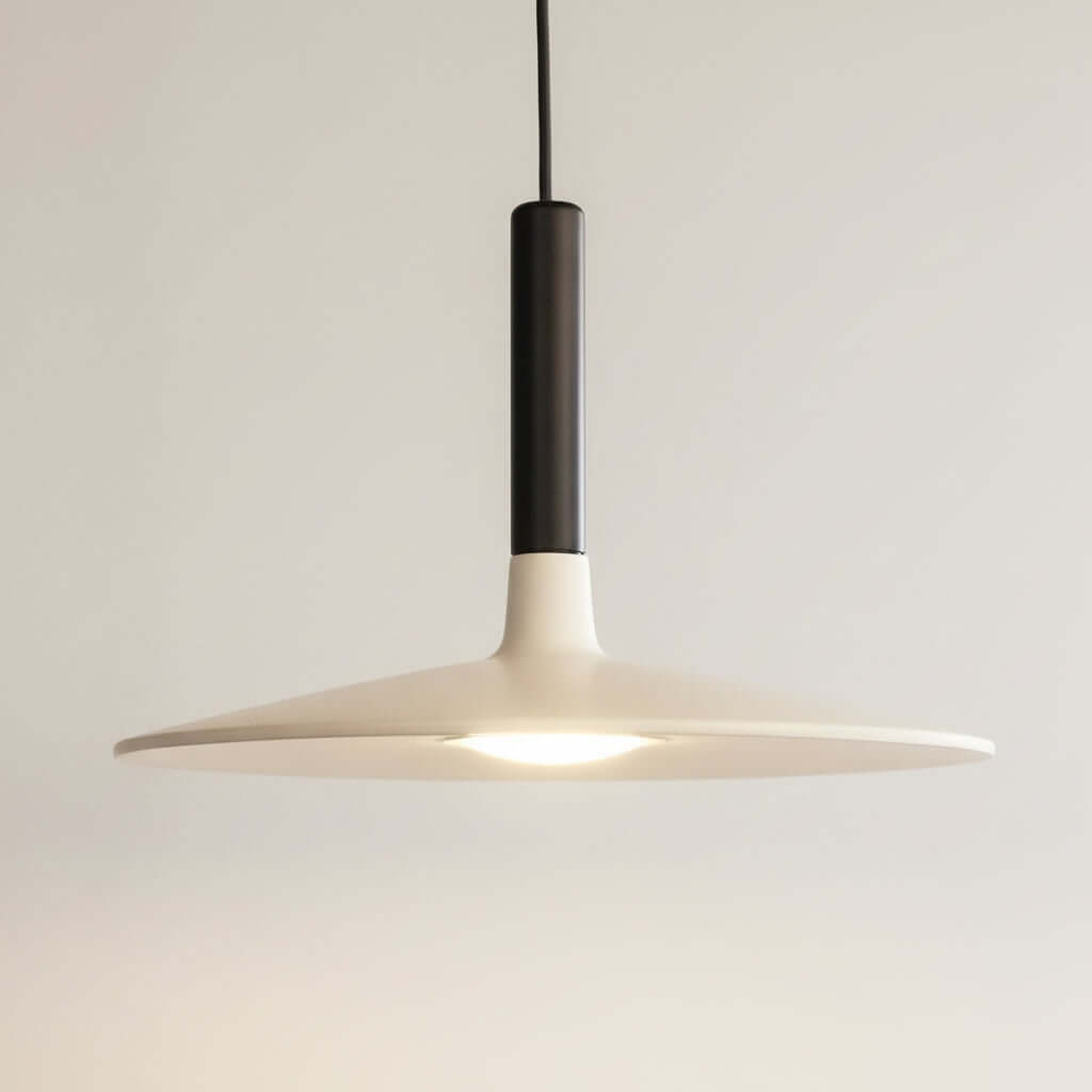 Modern pendant light with a dark fixture on a black background