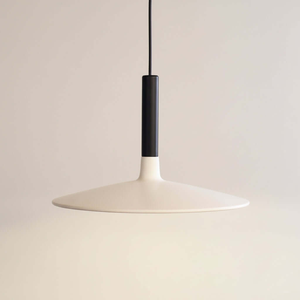 Modern pendant light with white shade and black fixture on a dark background