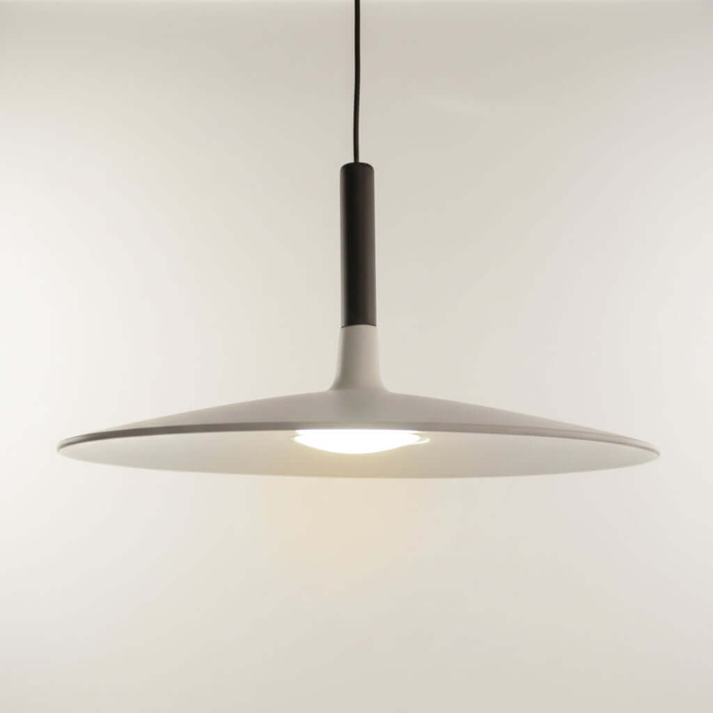 Modern pendant light with a white shade and black fixture on a neutral background