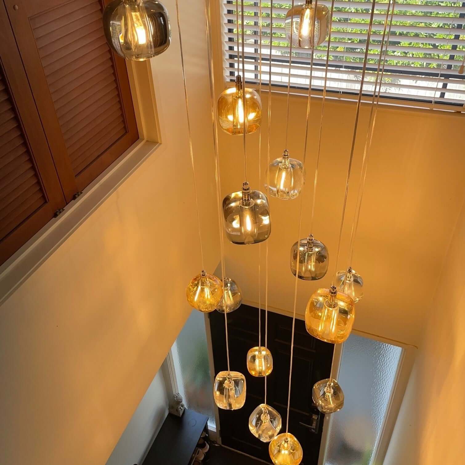 A group of Rocas pendant lights made of solid crystal with chrome fittings, hanging in a cluster to provide minimalist contemporary lighting.
