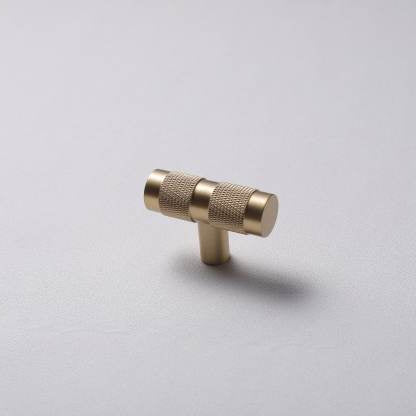 A solid brass T-pull cabinet handle against a white background