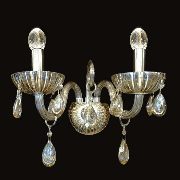 A beautiful Hera wall light with fluted arms and bowls, suspended teardrop crystals, and an antique brass finish.