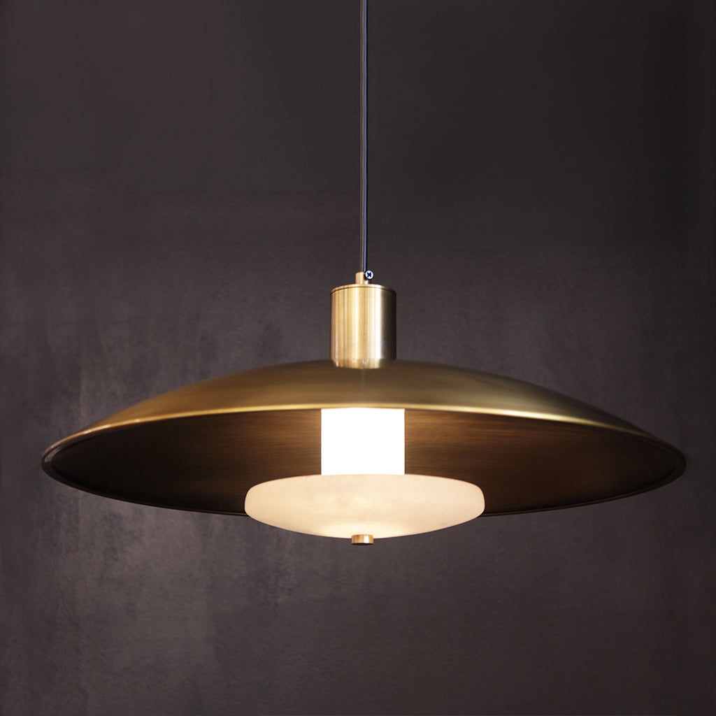 Gold pendant light against a dark background