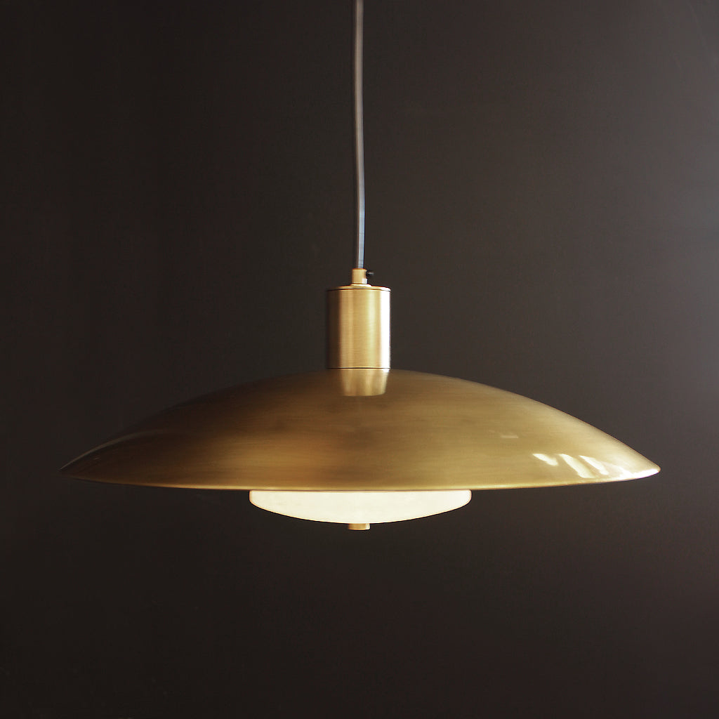 Gold pendant light against a dark background