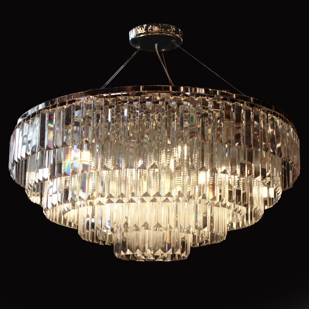Tiered chandelier with hanging clear prism crystals and chrome frame on a black background
