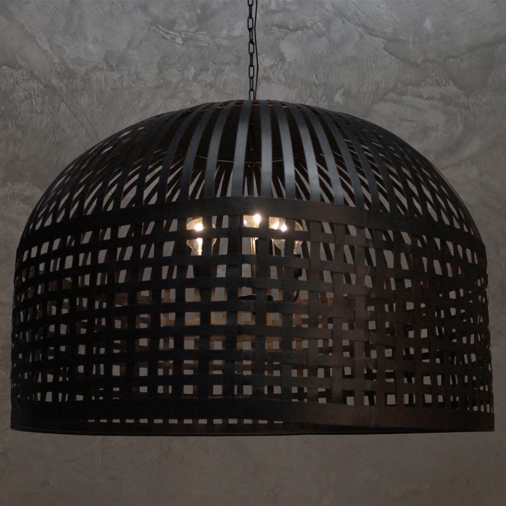 Dining room with wooden table and chairs under a large pendant light.