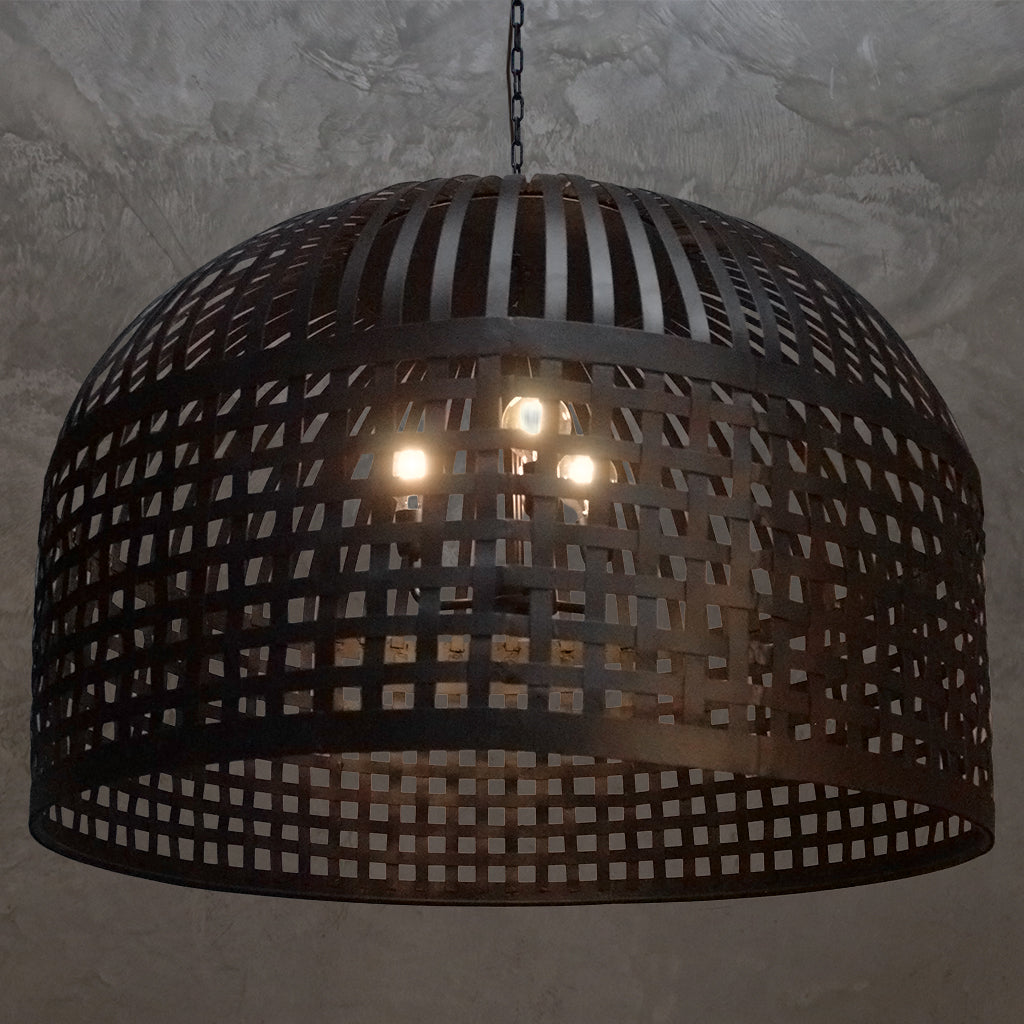 Black woven pendant light fixture on a textured wall background
