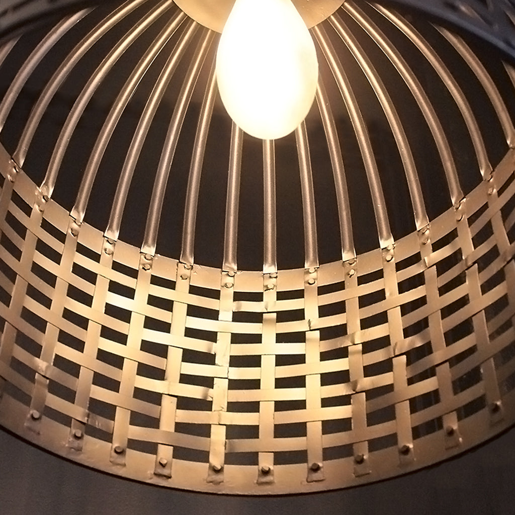 Close-up of a woven metal lampshade with a light bulb inside