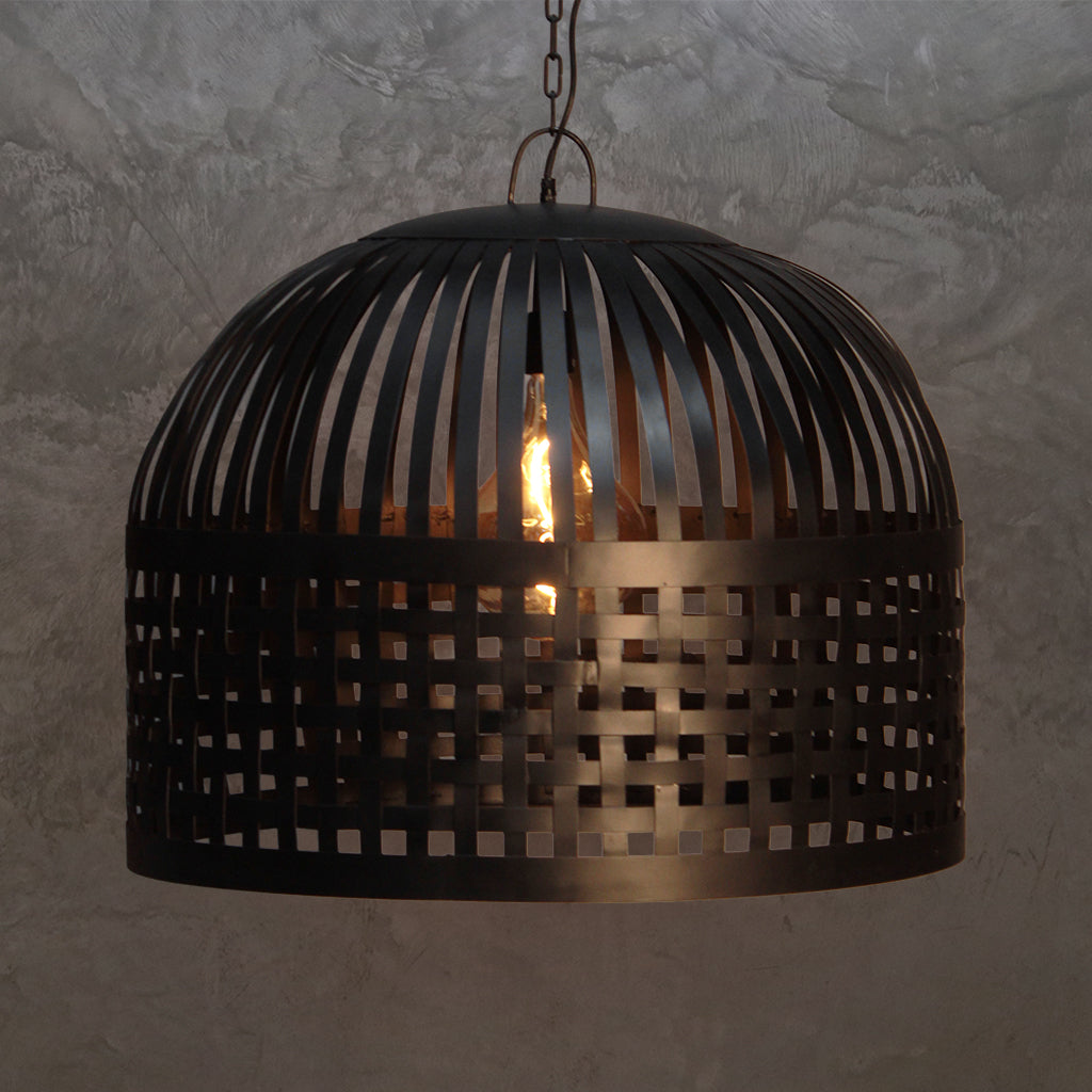 Black perforated pendant light against a textured wall