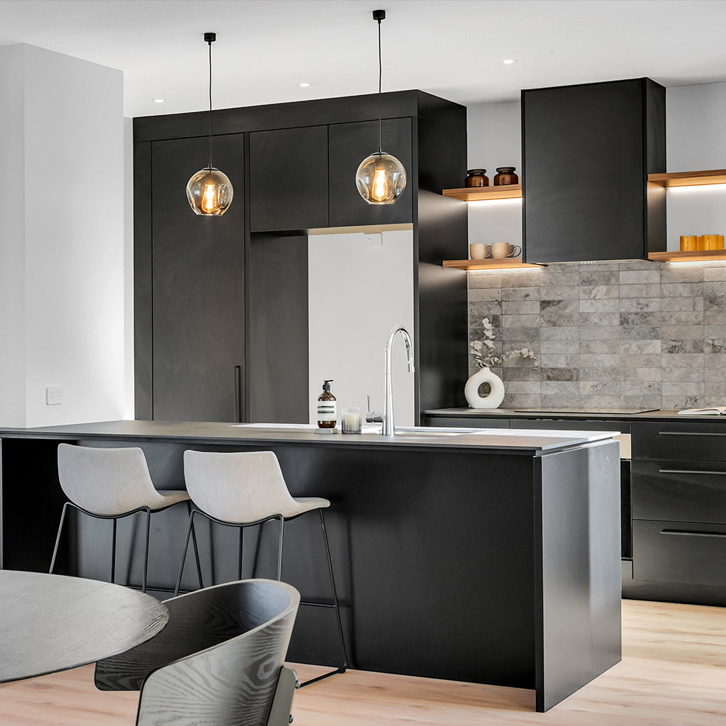 Two small modern smoked glass pendant lights over contemporary kitchen island