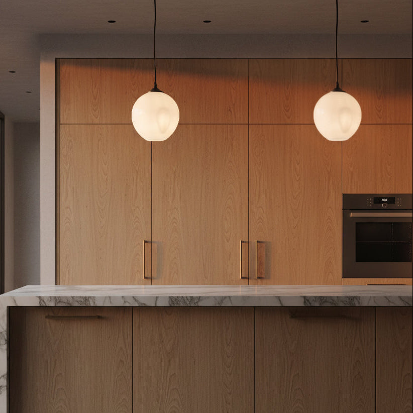 White glass pendant lights over modern kitchen island