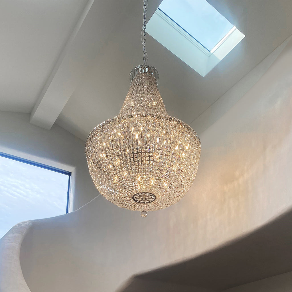 Chandelier hanging from the ceiling in a room with skylights.