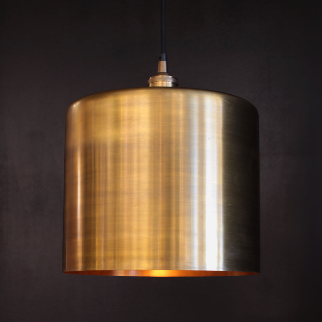 Brass pendant light against a dark background