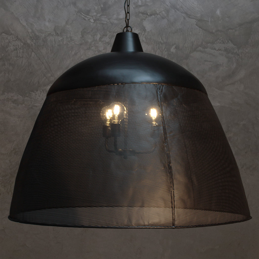Black pendant light with mesh shade against a textured gray wall