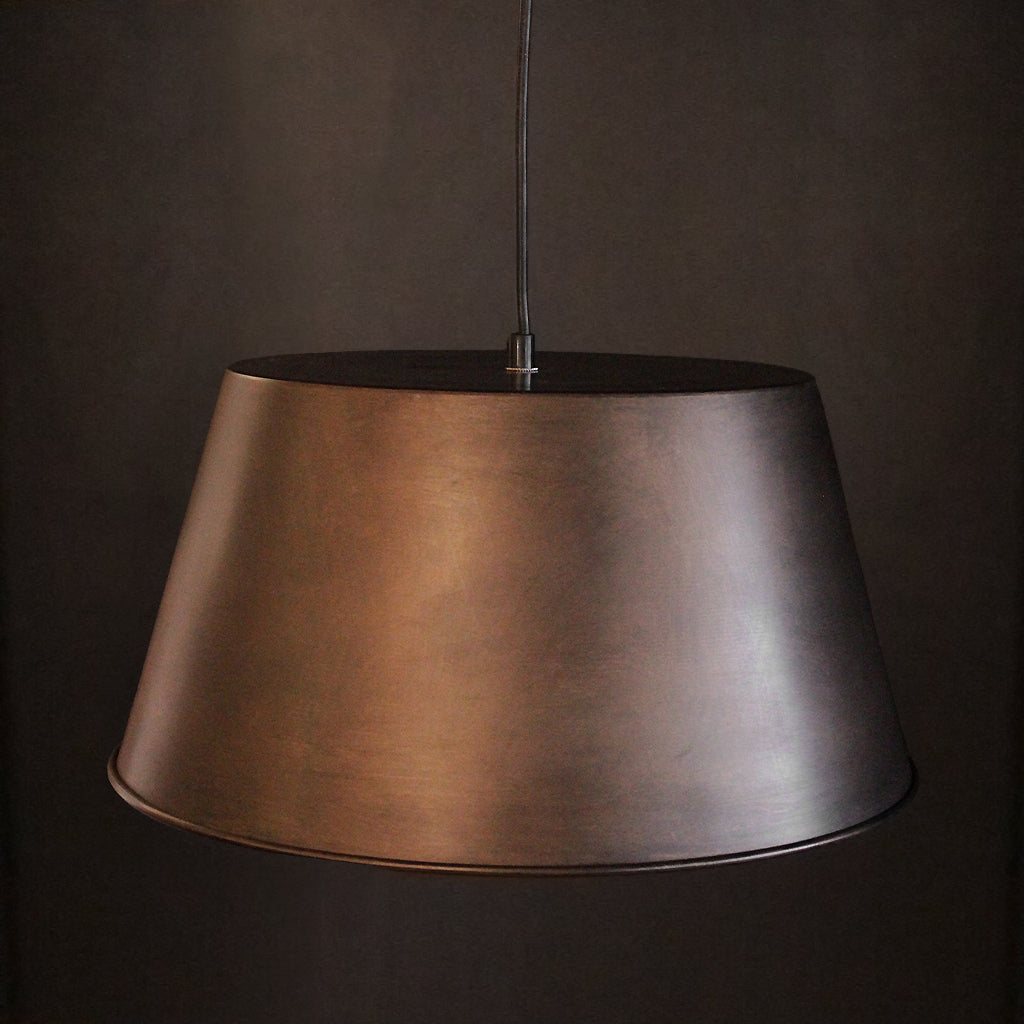 Tapering bronze pendant light shade against a dark background