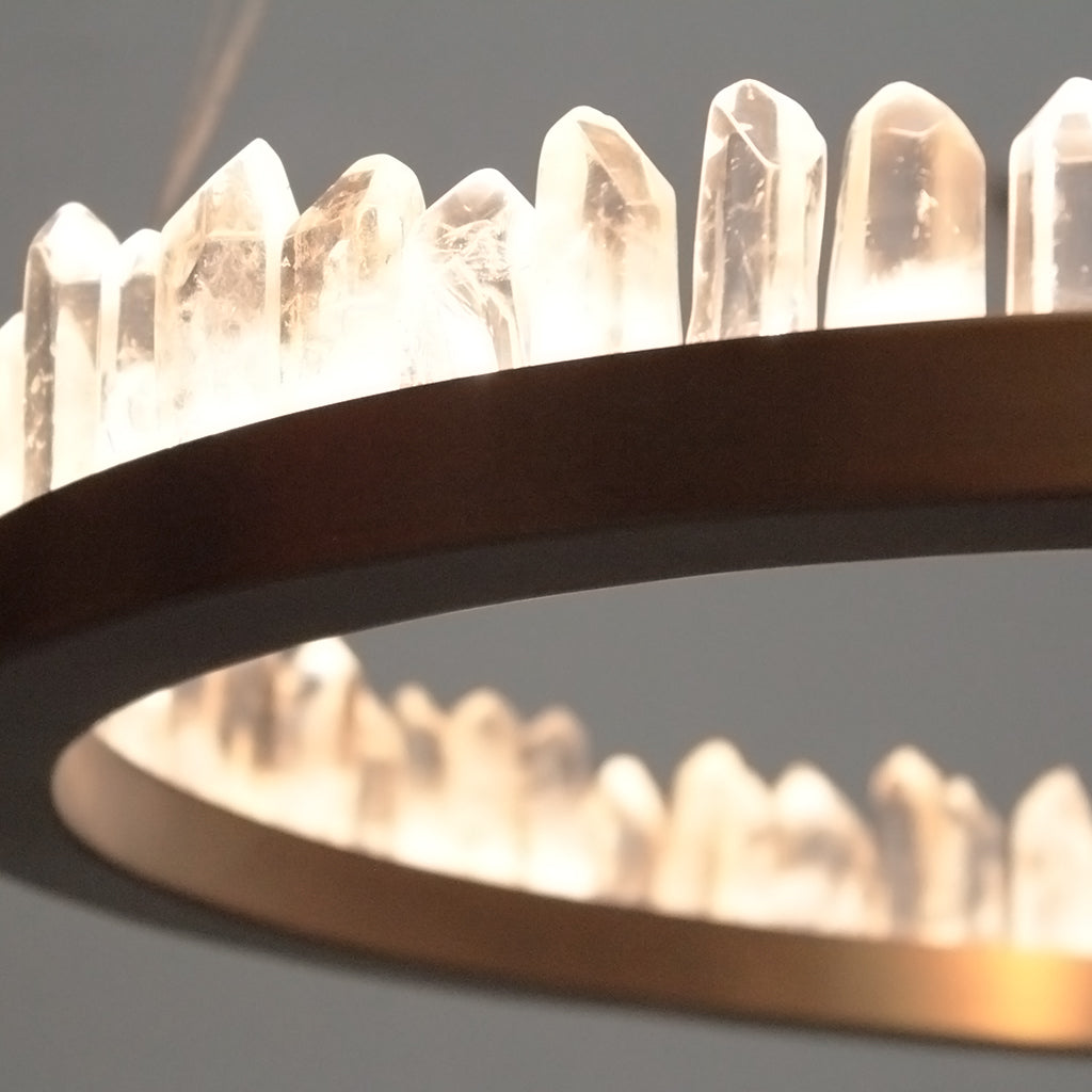 Close-up of a crystal chandelier with clear crystals and a dark metal frame.