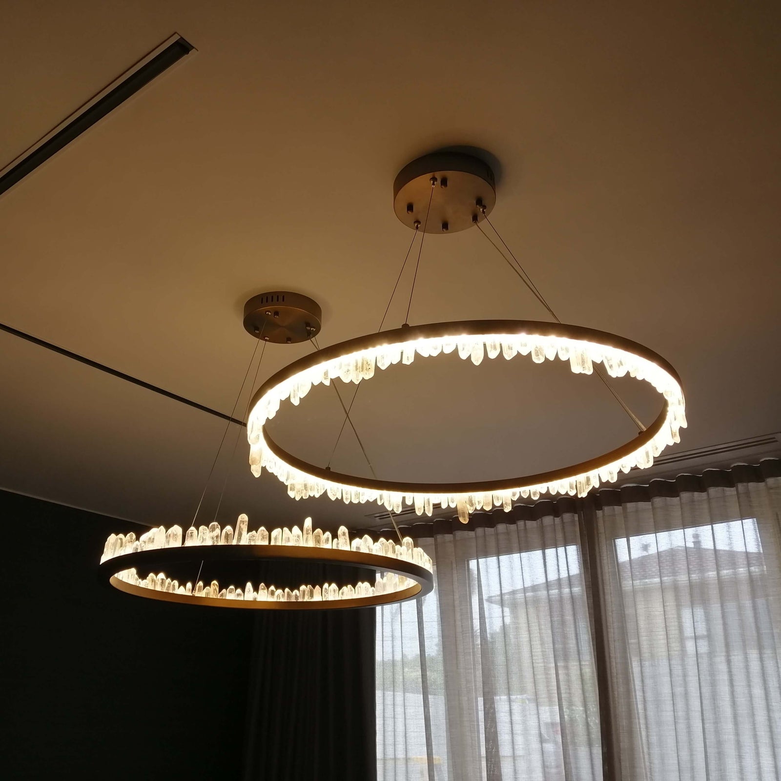 Antique Brass finished pendant light with natural crystals directed in various directions, suspended from the ceiling.