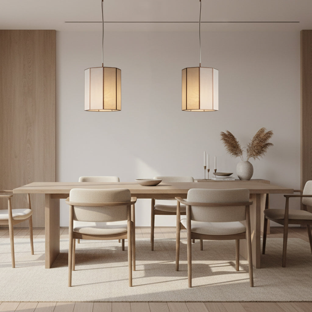 Dining room with wooden table and chairs, illuminated by pendant lights.