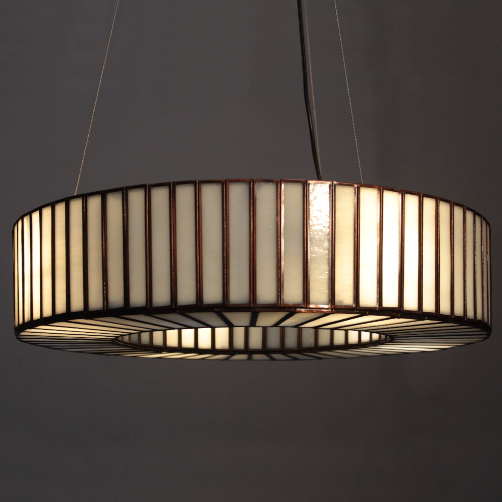 Modern pendant light with a cylindrical design on a dark background