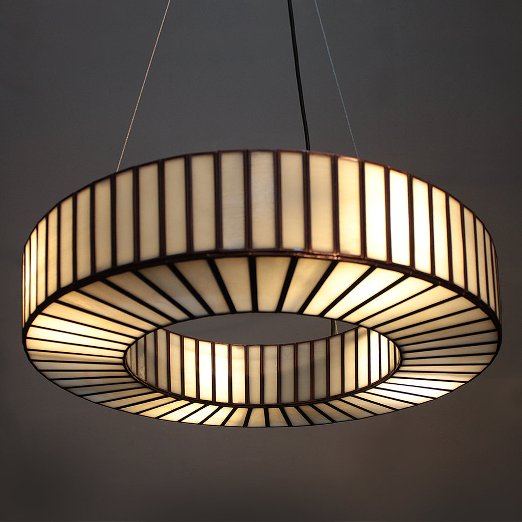 Decorative ceiling light fixture with striped design on a dark background