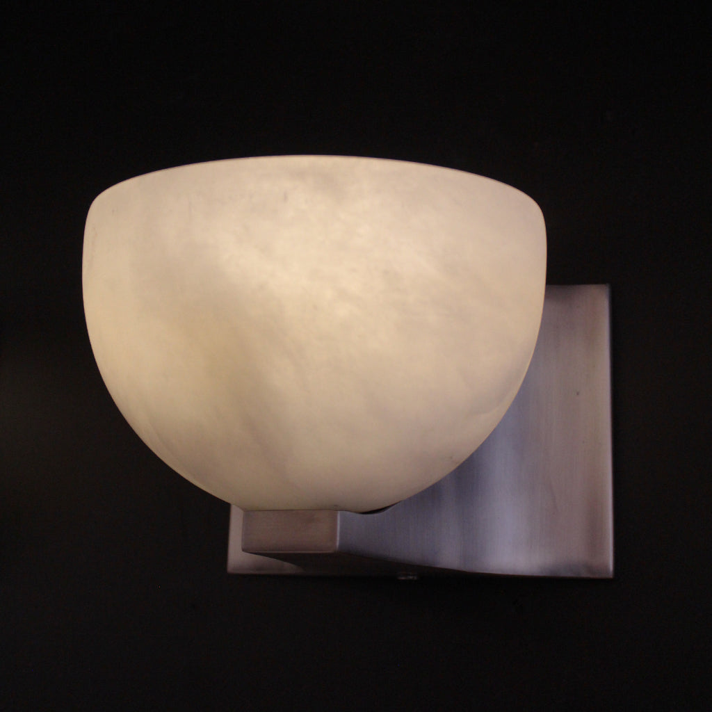 Wall-mounted light fixture with a white marble-like shade on a black background