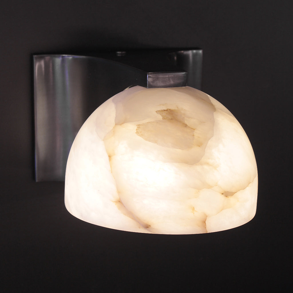 Wall sconce with marble-like shade on a black background