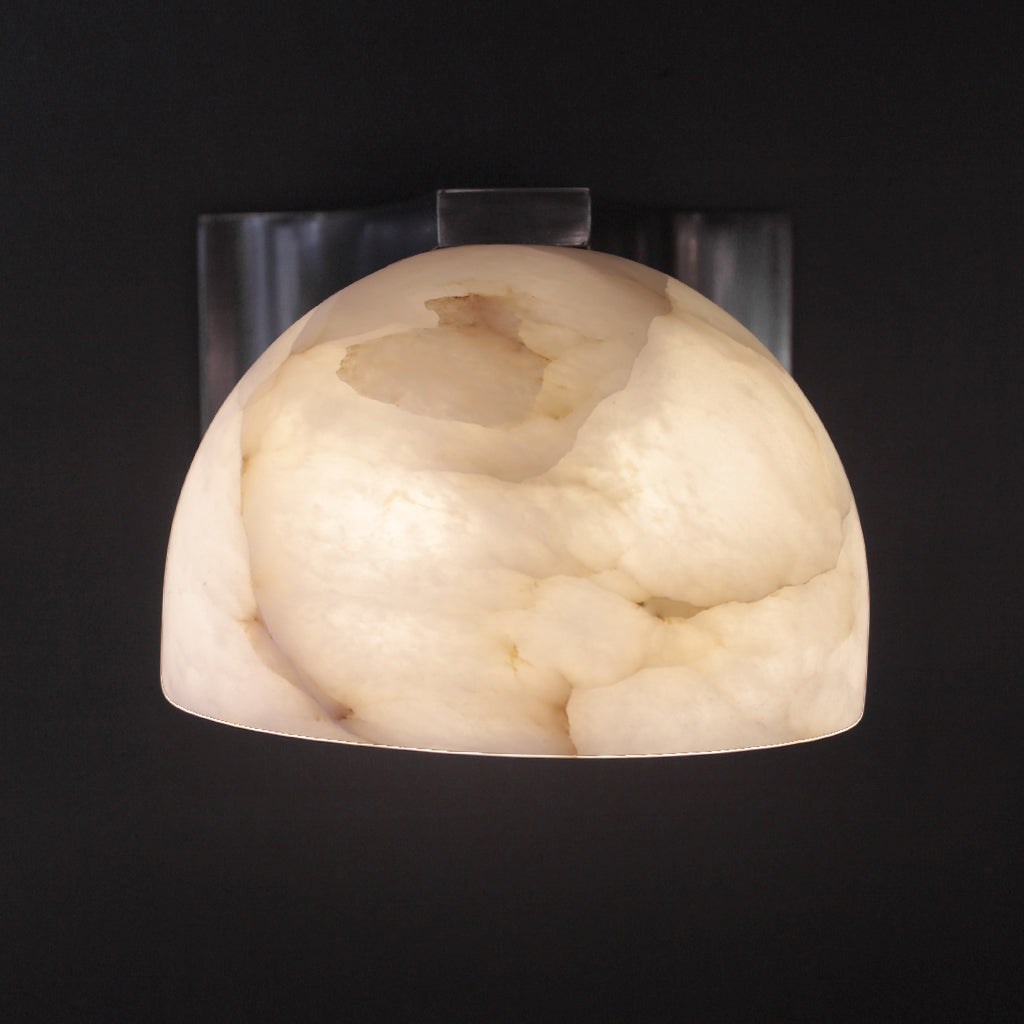 Decorative wall sconce with a marble-like finish on a black background